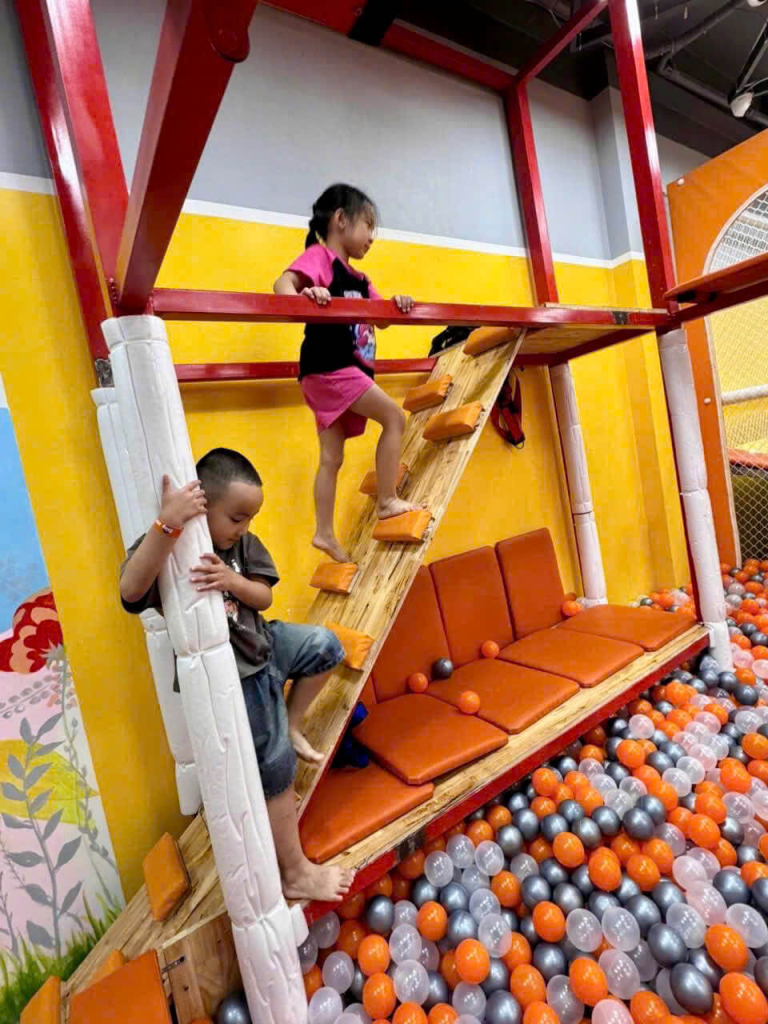 Trẻ em leo trèo với nụ cười vui vẻ tại khu vui chơi trong nhà