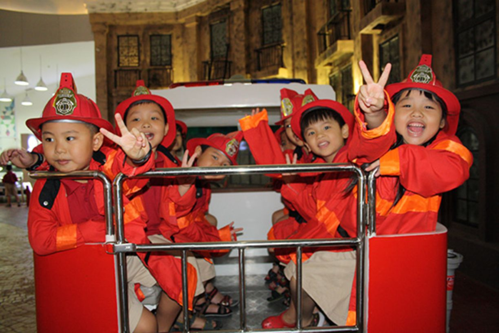 Các bé cùng nhau tham gia trò chơi nhập vai lính cứu hỏa trong khu vui chơi hướng nghiệp cho trẻ em